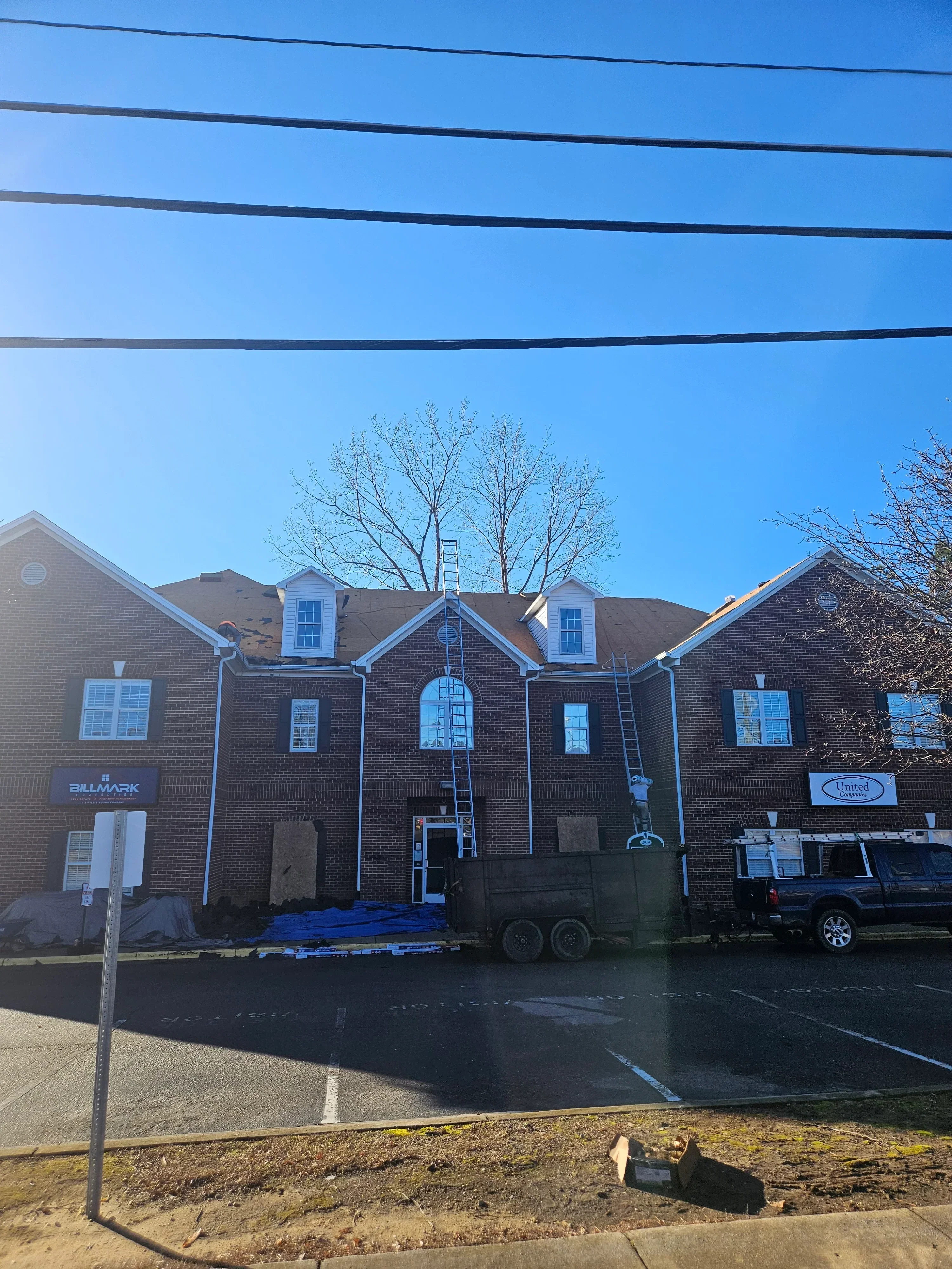 Multi-story brick commercial building with new metal roof flashing, gutters, and downspouts installed