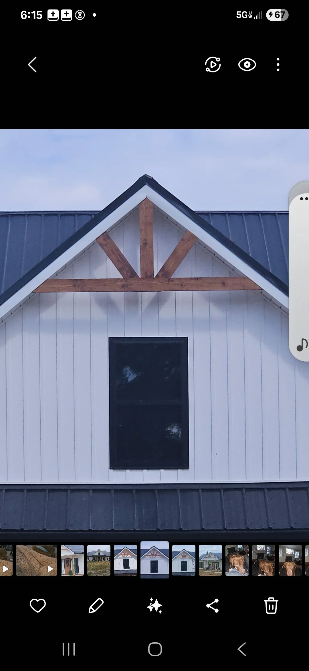 Metal standing seam roof with dark panels, white siding, and timber gable bracing on modern farmhouse structure