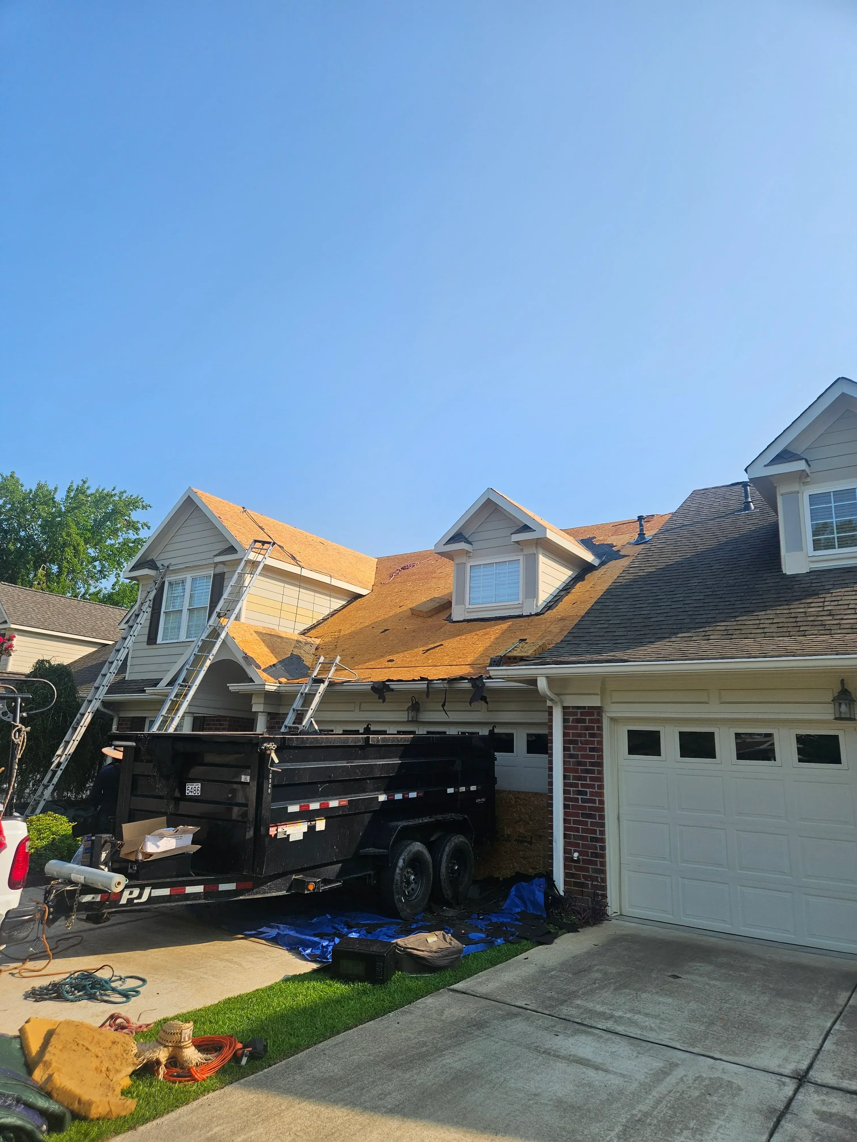 Two-story home with new charcoal gray architectural shingle roof installation on gable and main roof sections