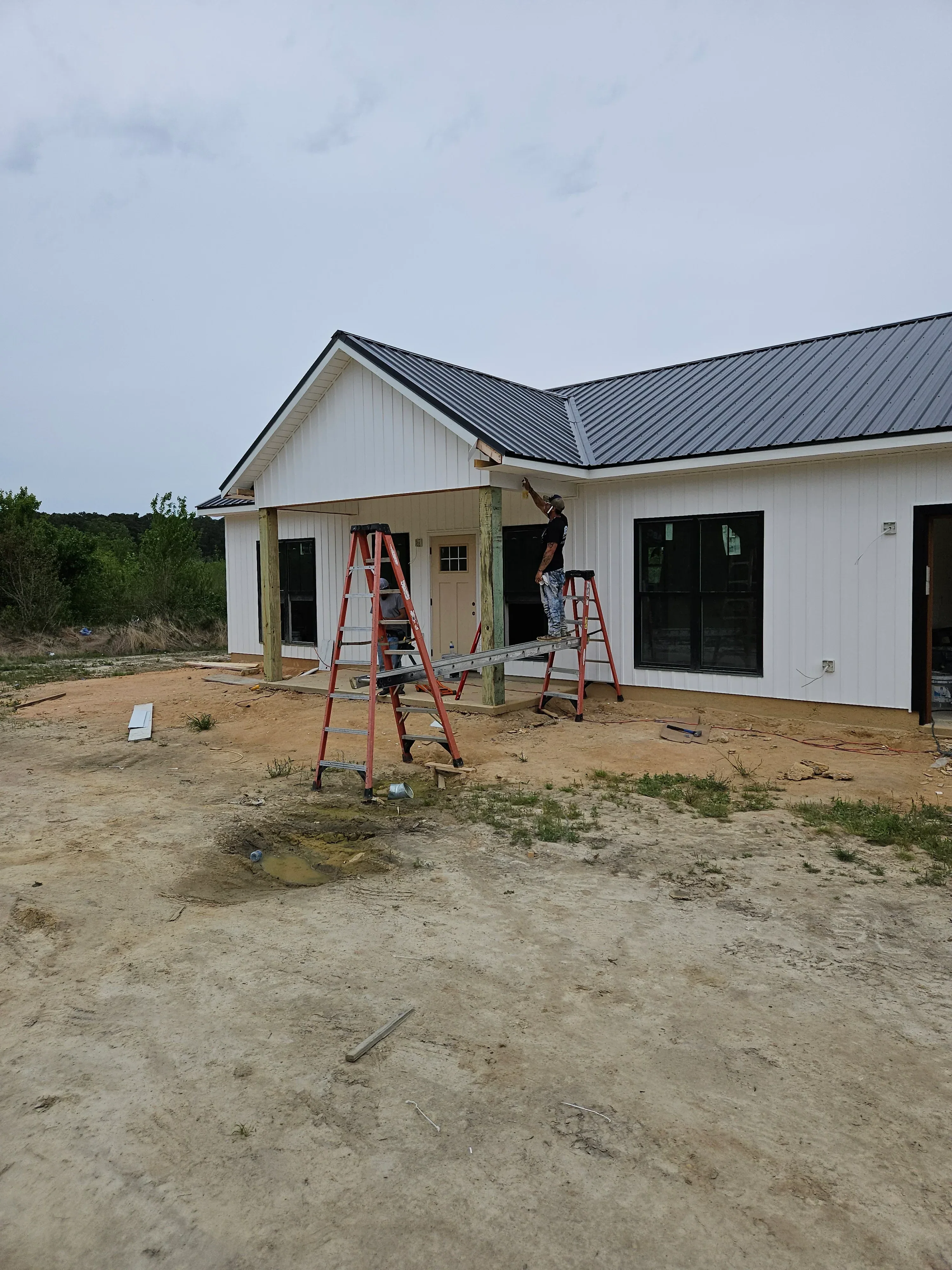 White horizontal lap siding with black four-pane window installation on residential home exterior
