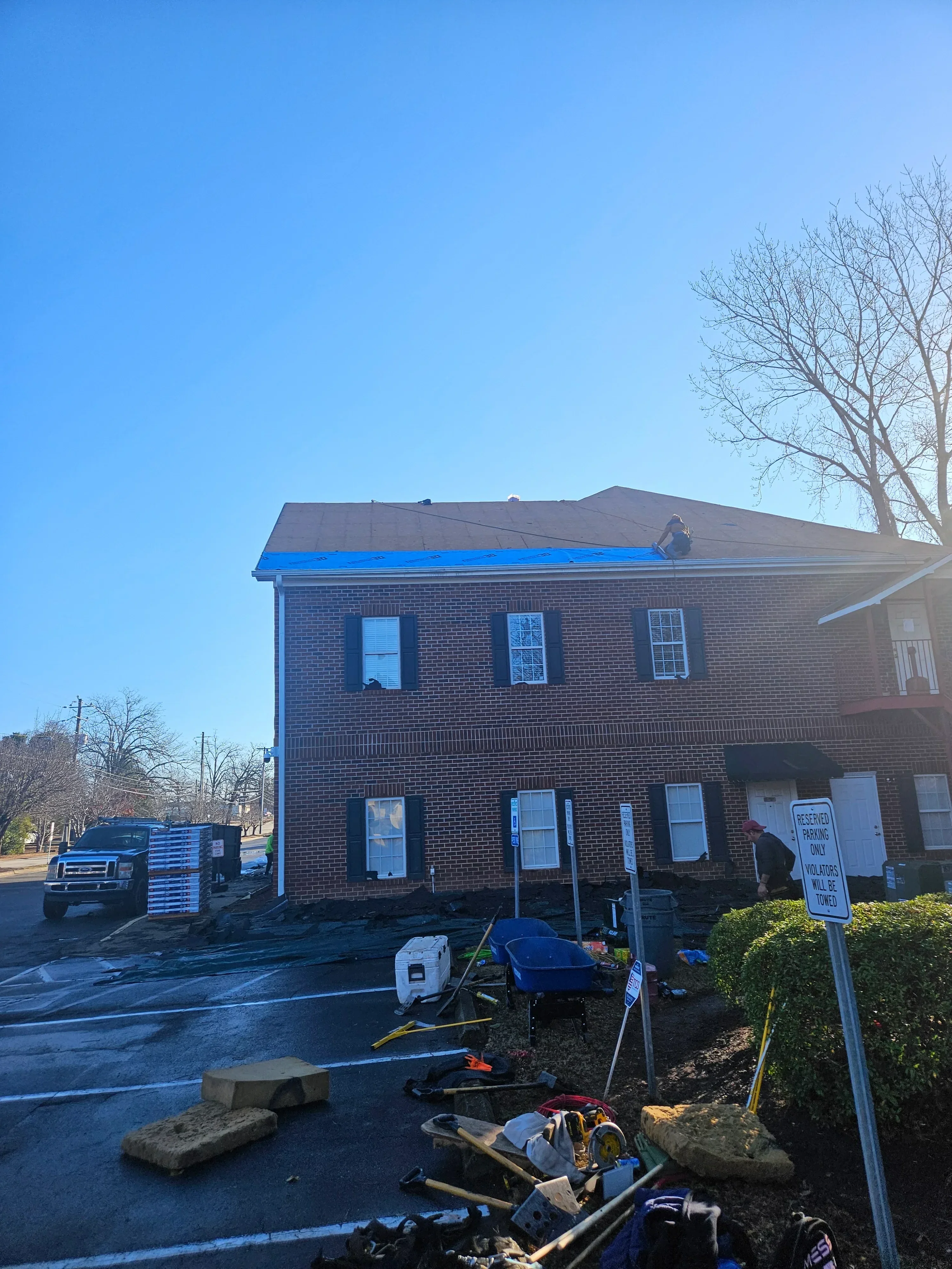 Brick building with new blue metal roofline trim and flashing installation on multi-story facade